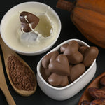 Chocolate candies in a white dish with a wooden spoon and pumpkin in the background